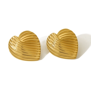 Detail of golden heart earrings with unique wavy lava texture and polished metallic finish