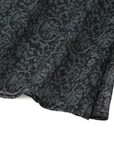 Macro detail of dark grey shirt fabric showing intricate jacquard texture and vertical stripes