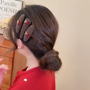 Detailed view of plush triangular hair clips with cherry and bow accents on hair