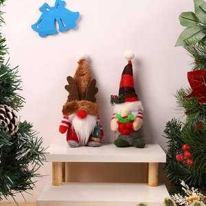 Christmas gnome doll set with reindeer antlers and plaid hat on a white display stand