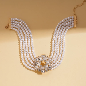 Detail view of a six-layer faux pearl necklace with a large crystal cluster pendant