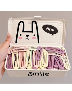Detailed close-up of colorful matte candy-colored drop-shaped hair clips in a metal box