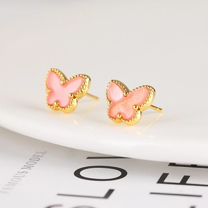 Close-up of pink butterfly stud earrings with gold beaded edges and refined enamel finish