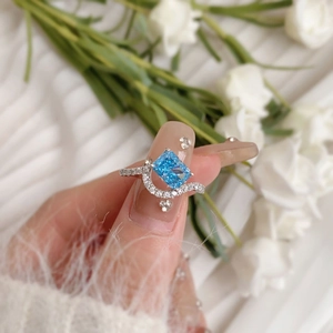 Detailed view of S925 silver ring featuring a large blue zircon on a model's hand