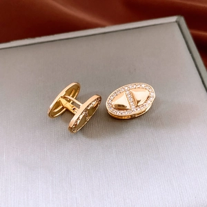 Macro shot of 18K gold plated oval earrings with pavé zircons and anchor link design