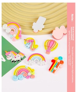 Detailed macro shot of various resin charms featuring unicorns, rainbows and clouds