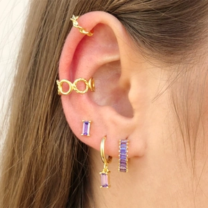 Detail of bohemian gold ear cuffs and earrings set with purple crystal gemstones