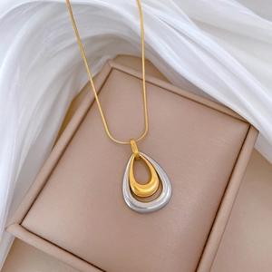 Detail of double-layer water drop pendant necklace with gold snake chain on pink box
