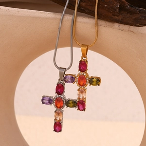 Detail of gold and silver cross pendants with colorful crystals on snake chains