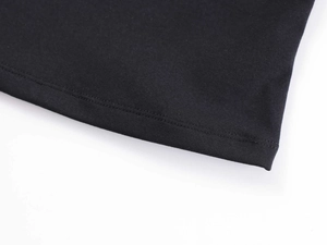 Vista macro della doppia cucitura sull'orlo del top a fascia nero in maglia elastica