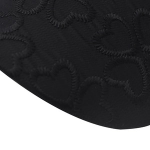 Close-up of black lace baseball cap featuring intricate heart-shaped embroidery texture