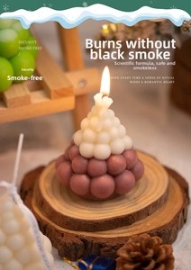 Close-up of lit Christmas tree scented candle on wood slice with pinecone decor