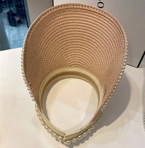 Top view of straw sun visor with pearl trim and lightweight woven texture
