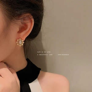 Elegant gold oval stud earrings with pearls and opal stone on female model
