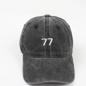 Macro detail of number 77 embroidery on vintage washed cotton grey baseball cap