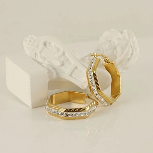 Elegant geometric gold-plated titanium earrings with sparkling crystals on artistic props