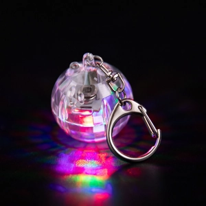 Close-up of a glowing disco ball keychain with colorful LED light and silver metal hook