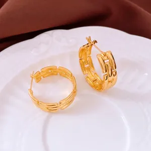 New Chinese gold-plated geometric interlocking hoop earrings on an elegant white plate