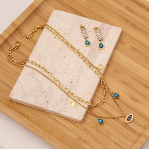 Golden double-layered evil eye and blue teardrop necklace with matching earrings set