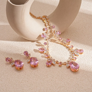 Détail d'une parure bijoux fleur de goutte avec pierres roses et plaqué or