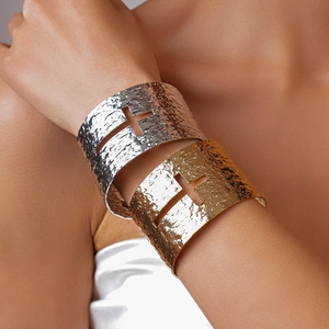 Detail of cross cutout and hammered texture on gold and silver wide open bangles