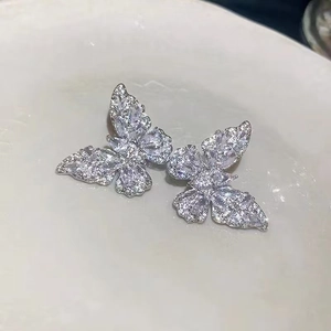 Detailed close-up of sparkling cubic zirconia butterfly ear clips in silver finish