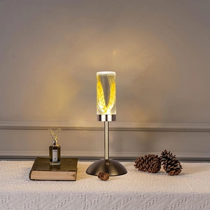 Detail of the acrylic table lamp featuring glowing wheat ear patterns and a bronze base
