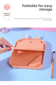 Close-up of foldable rabbit ear makeup mirror showing thickened PP material and pink finish