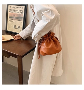 Schultertasche aus PU-Leder in Karamellbraun mit Kordelzug am Model getragen
