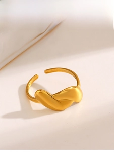 Close-up of a gold minimalist twisted knot ring with a polished metallic finish