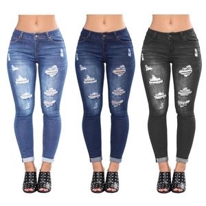 Close-up of skinny ripped jeans in light blue, dark blue, and black washes with distressed details