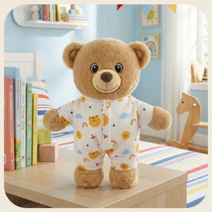 Detailed view of a soft brown teddy bear plush in cute printed pajamas on a wooden desk