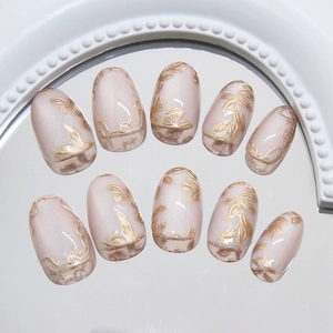 3D gold floral relief press-on nails with cat eye finish on oval nude pink jelly base