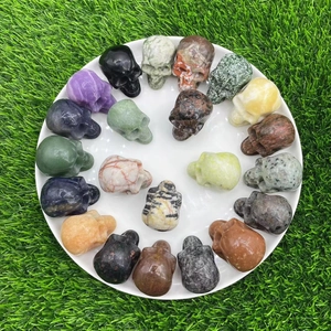 5cm natural gemstone crystal skulls in various stones arranged in a spiral on grass