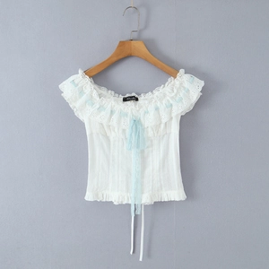 Detail of French lace top with light blue ribbon bows and ruffled off-shoulder neckline