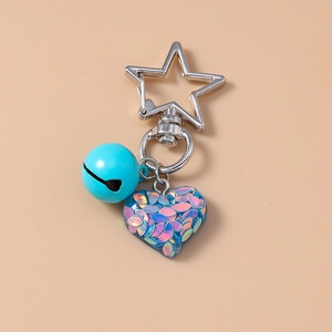 Detail of star-shaped clasp with blue bell and glitter heart resin keychain