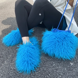 Close-up of blue faux sheepskin bucket bag and matching plush boots in outdoor setting