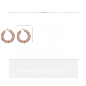 Detail view of geometric hoop earrings with pearls and rhinestones on a white background