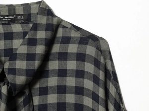 Detailed close-up of gray and navy plaid shirt collar with high-quality stitching and brand label