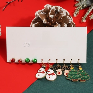 Detail of Christmas earring set with snowman, tree and reindeer motifs in red and green enamel