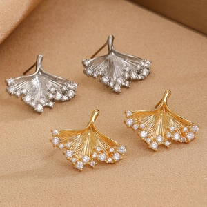 Detail of ginkgo leaf stud earrings in gold and silver set with cubic zirconia stones