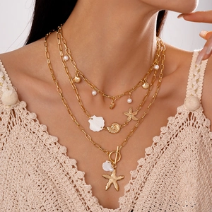 Three-layer gold necklace set featuring starfish, conch pendants and faux pearls on model