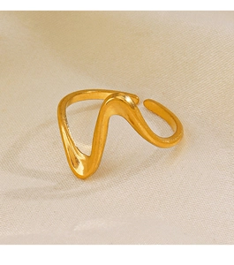 Detail of minimalist wavy gold plated stainless steel ring on beige textured fabric