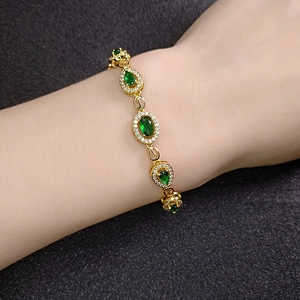 Elegant gold chain bracelet featuring oval green gems and sparkling crystals for women
