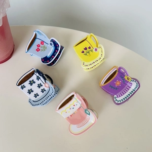 Detail showing acrylic coffee cup hair claws with floral patterns in five pastel colors