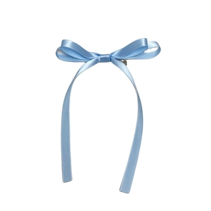 Detail of light blue satin ribbon bow hair clip with long streamers on white background