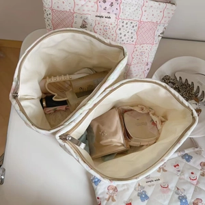 Top view of large capacity quilted makeup bag with floral print and interior storage items