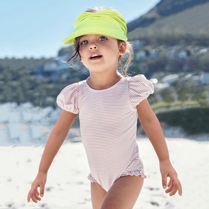 Detail of neon yellow knitted sun visor hat for toddlers on a sunny beach background