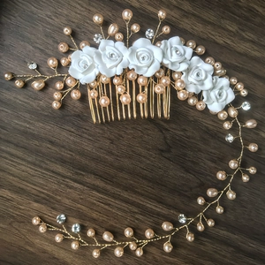 Exquisite bridal hair comb with ceramic roses, pearls, and crystals on a wood background