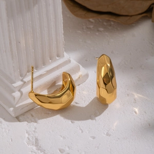 Gros plan détaillé de boucles d'oreilles croissant dorées avec texture martelée fine
